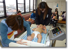 身体測定のようす。赤ちゃんが寝ていて、保健師たちが測定しています。