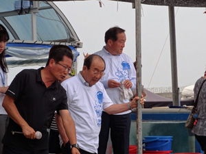 イカ祭で、桟橋の上から束草市長と米子市長が海をのぞいています