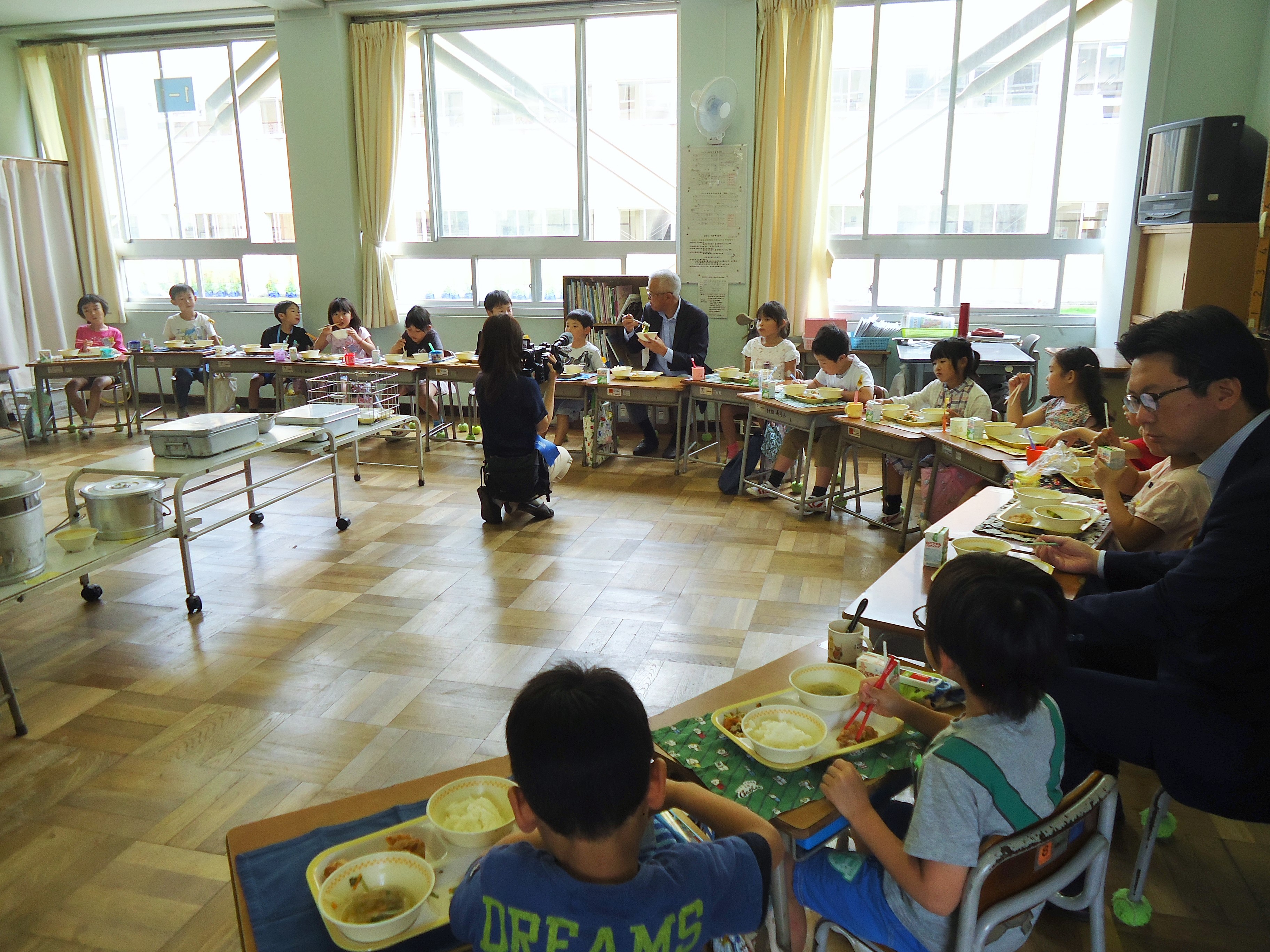 義方小学校1年1組の児童たちが、おいしそうに給食を食べています。