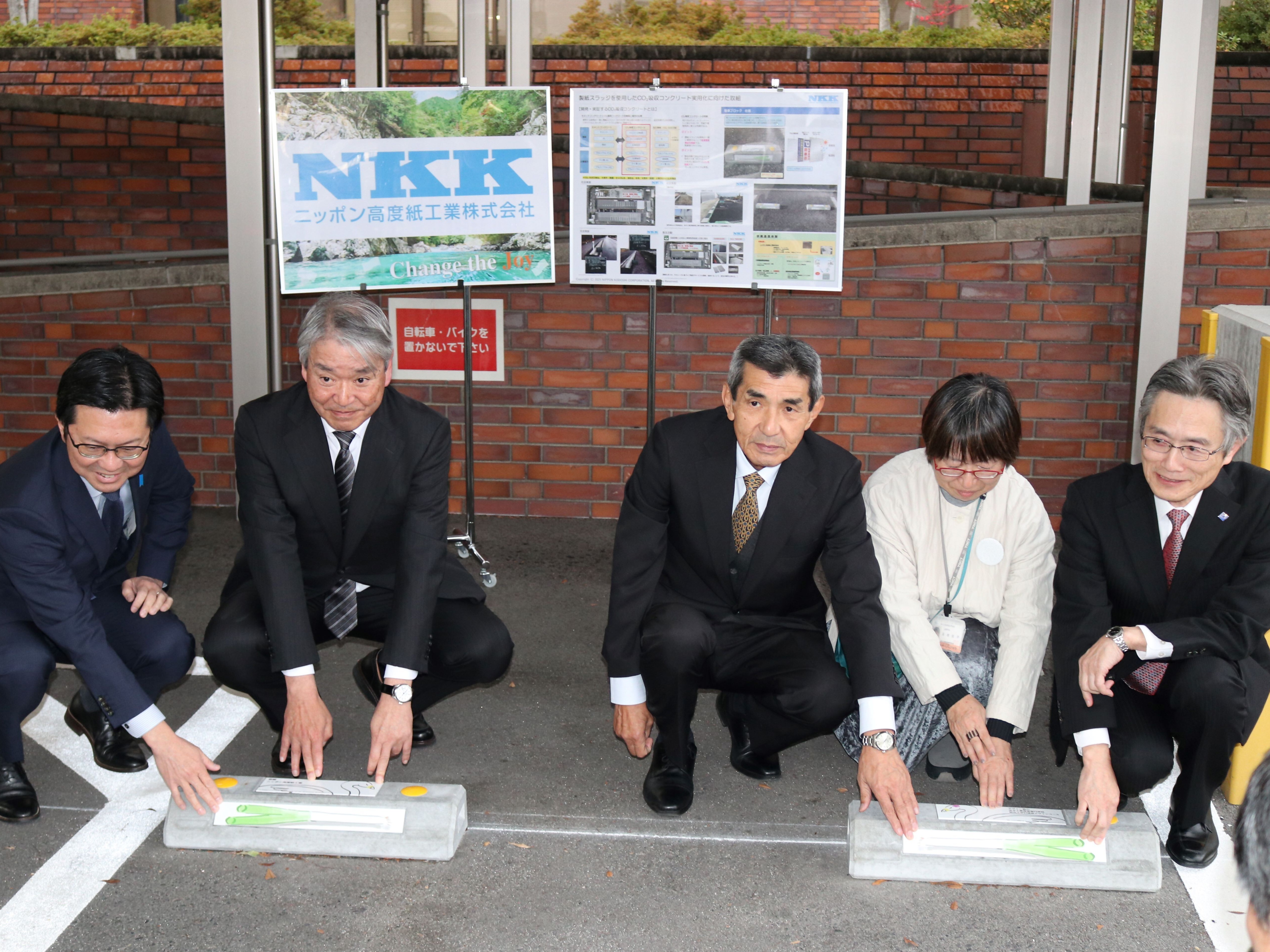 車止めブロックにプレートを設置するセレモニーの様子