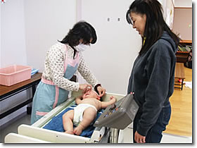 身体測定の写真。保健師が赤ちゃんの測定をしています。